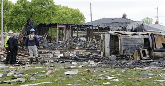 Investigators look over the damage after a house explosion on Wednesday in Cleveland. The blast demolished an apparently unoccupied home, leaving a hole.